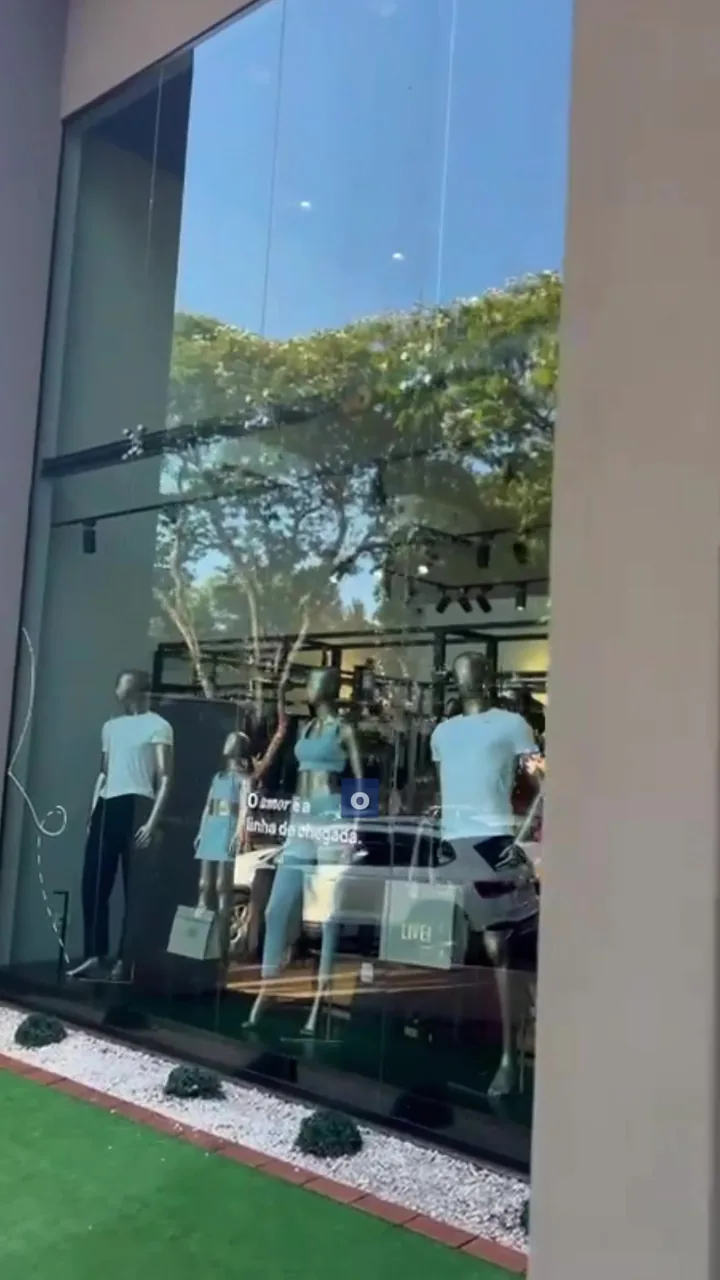 Vitrine de loja com vidro limpo refletindo a rua, em Maringá