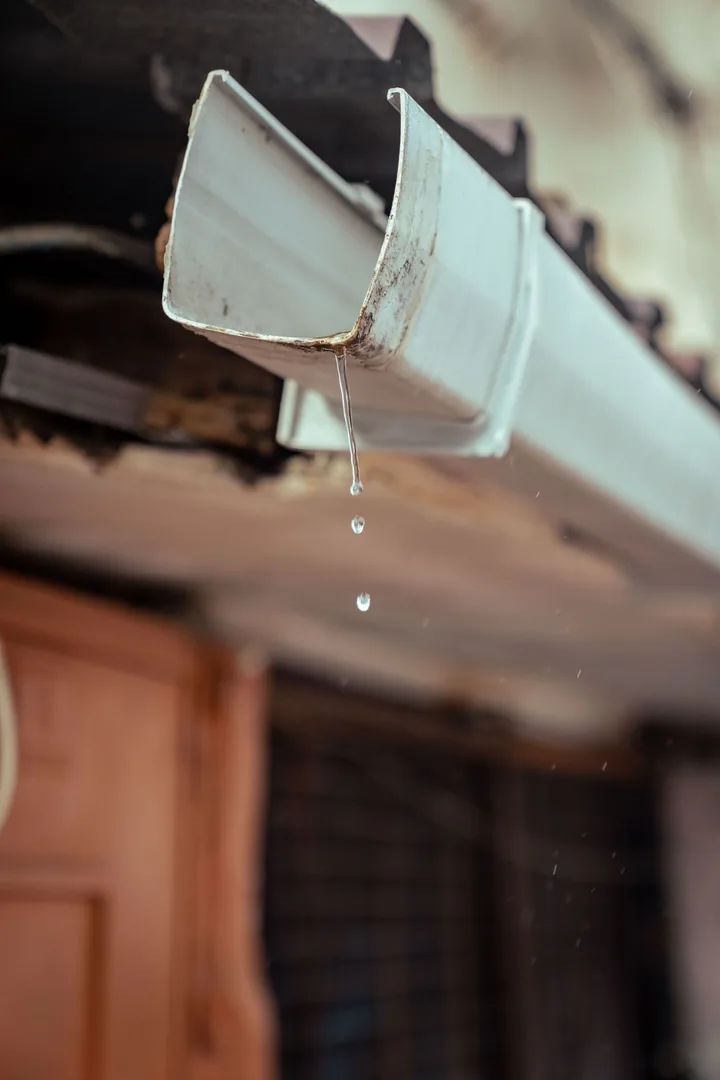 Bocal de calha de casa com água escorrendo depois da chuva