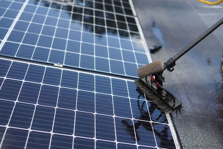 Escova de cabo limpando um painel solar molhado